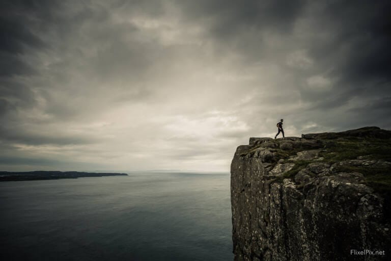 a person walking on a cliff edge